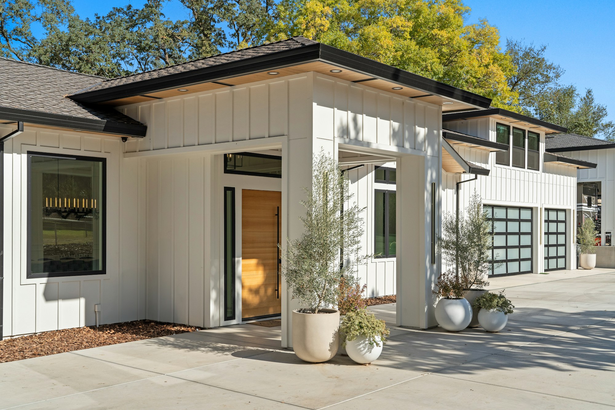 Installed white board-and-batten siding with broad vertical boards and narrow raised battens on a modern house