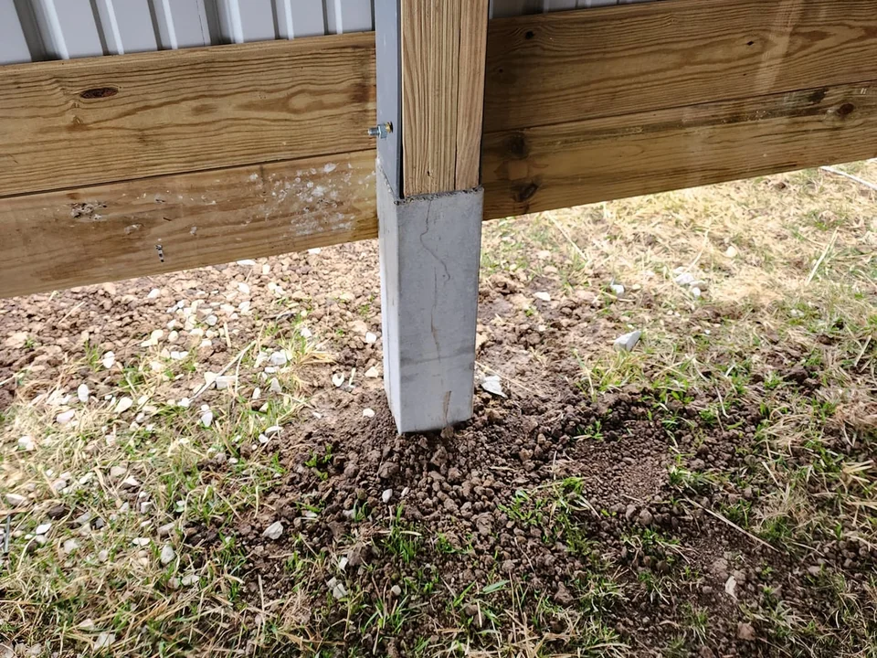 Precast concrete column and steel bracket supporting a timber post above grade