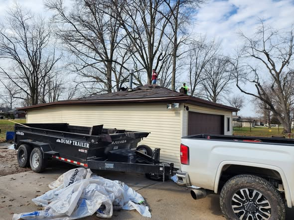 Roofing crew working on a detached garage shingle roof